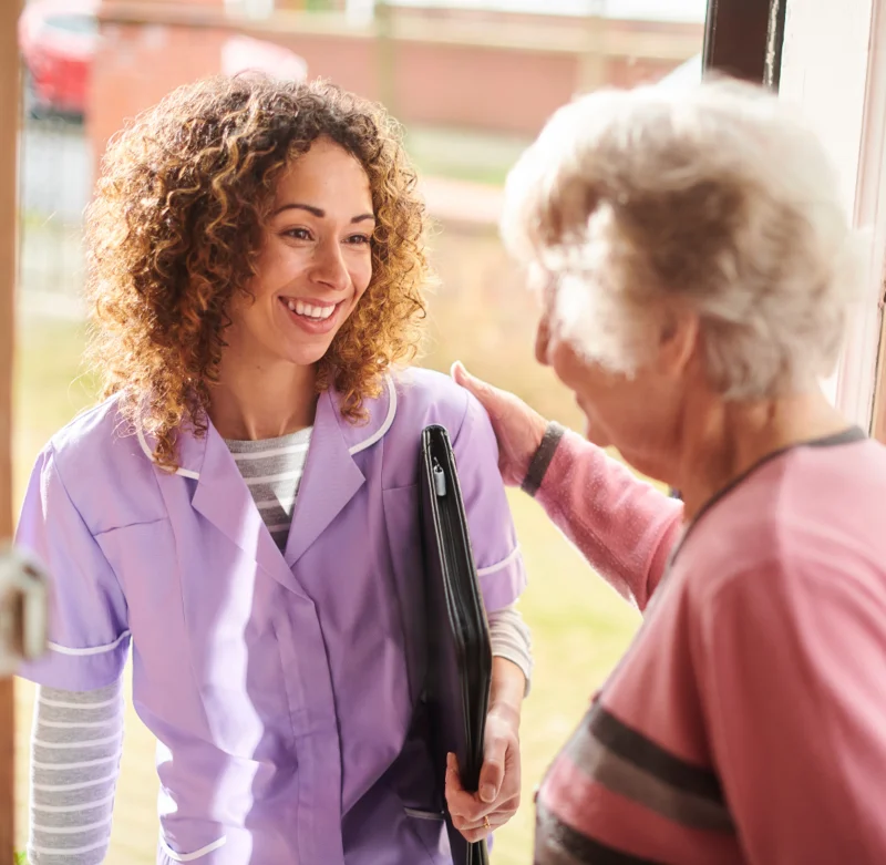 Caregiver assisting an elderly woman at home during post-surgery recovery, providing support for family caregivers