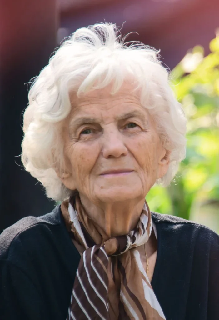 Portrait of an elderly woman outdoors, representing compassionate senior care for Enterprise residents