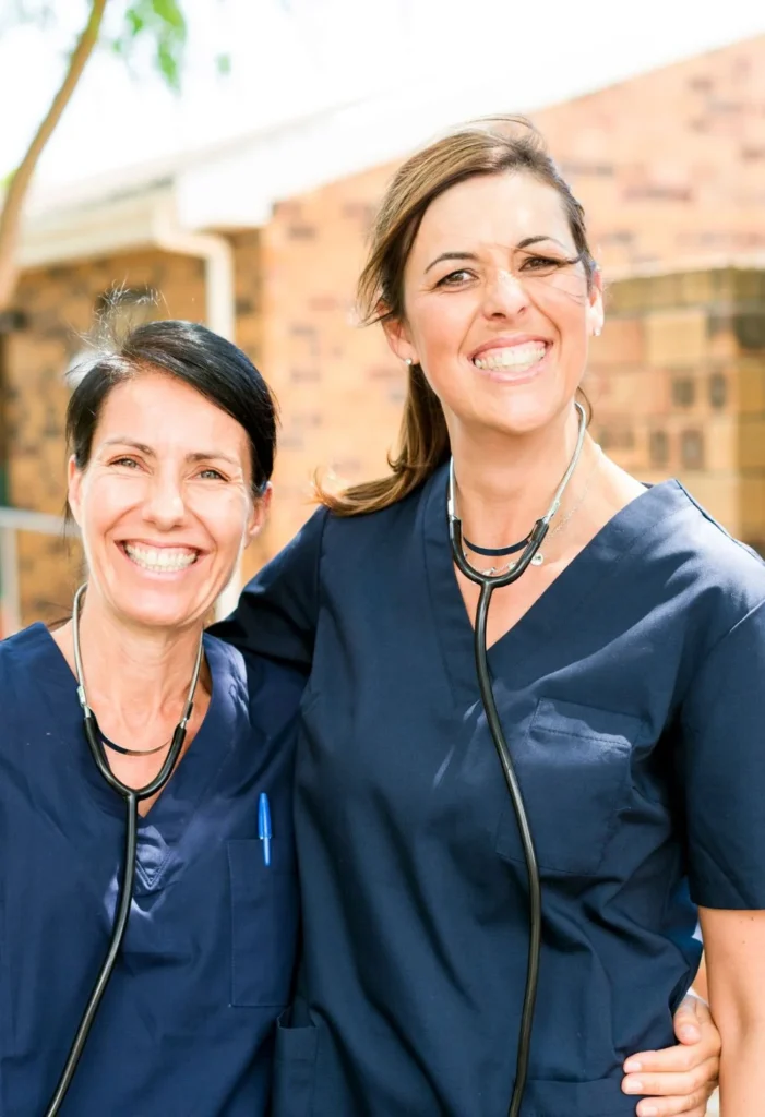 Two smiling caregivers standing together, representing compassionate senior care for Las Vegas residents
