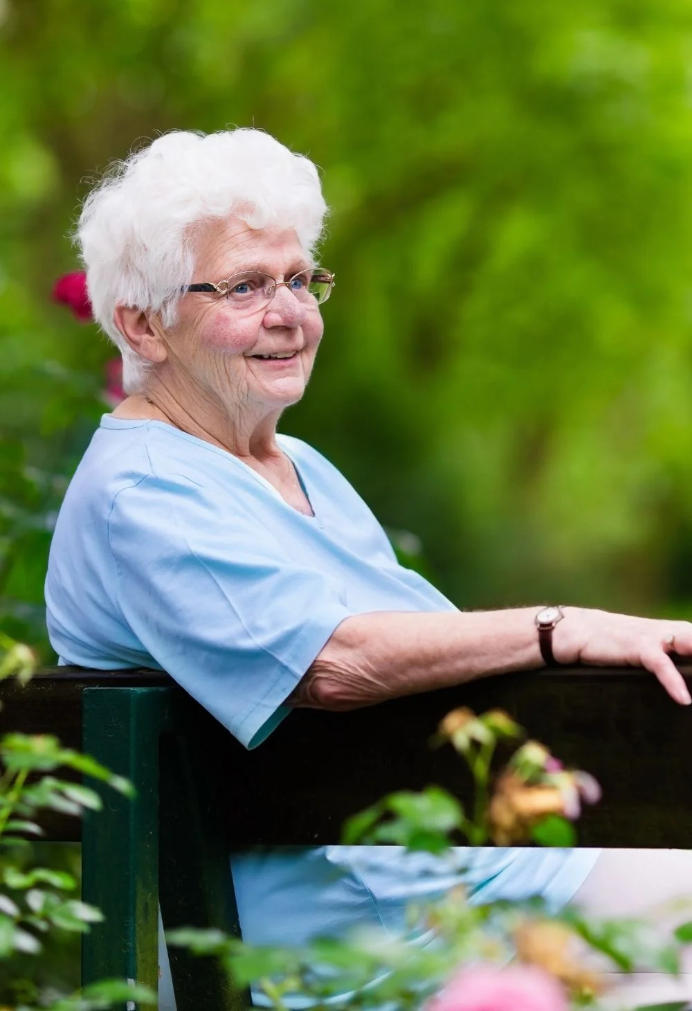 Smiling elderly woman sitting outdoors on a bench, representing compassionate senior care for Laughlin residents
