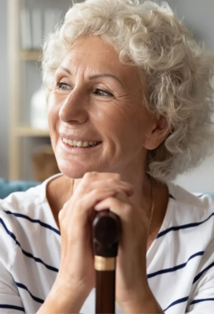 Smiling elderly woman holding a cane, representing compassionate senior care for Southern Highlands residents
