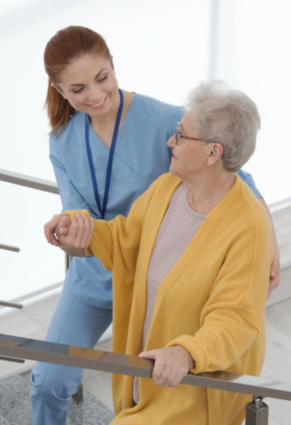 Caregiver assisting an elderly woman on the stairs, representing compassionate senior care for Spring Valley residents