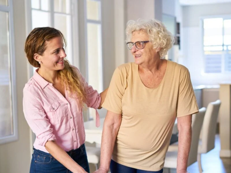 Caregiver assisting an elderly woman while walking at home, representing exceptional senior home care in Enterprise Nevada