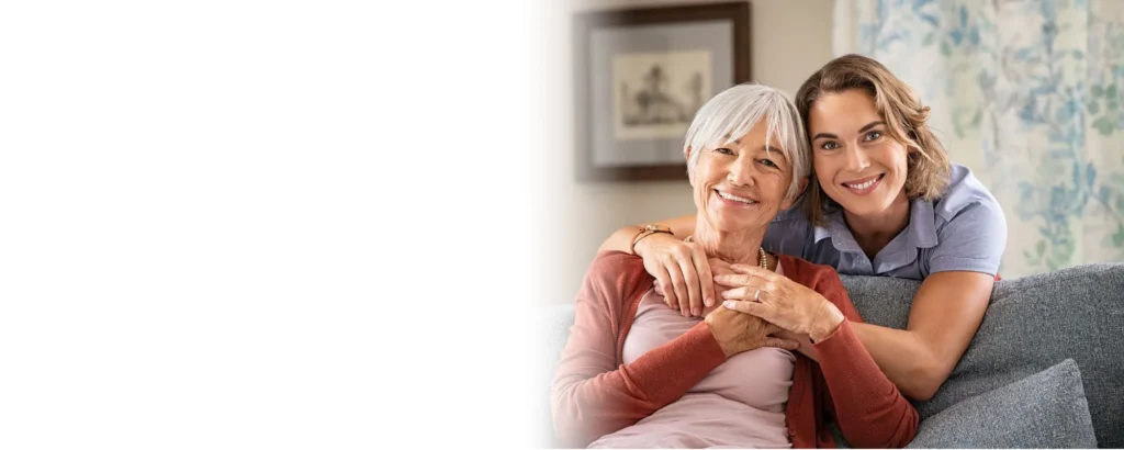 Smiling caregiver embracing an elderly woman at home, representing trusted home care services in Centennial Hills Nevada