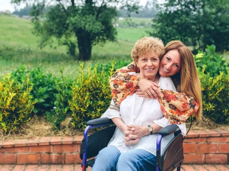 Smiling caregiver embracing an elderly woman at home, representing trusted home care services in Centennial Hills Nevada