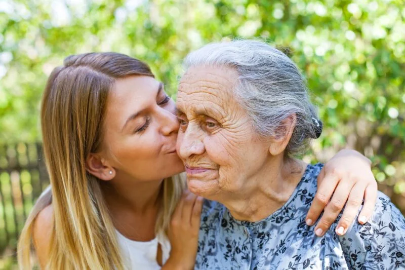 Young woman showing affection to an elderly woman, representing compassionate senior home care in MacDonald Highlands Nevada