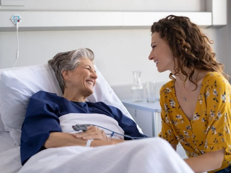 Smiling senior woman sitting with a supportive caregiver, representing a trusted home care provider in Henderson Nevada