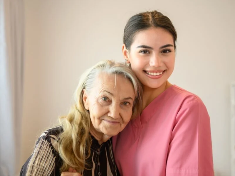 Smiling caregiver embracing an elderly woman at home, representing compassionate home care in Paradise Nevada