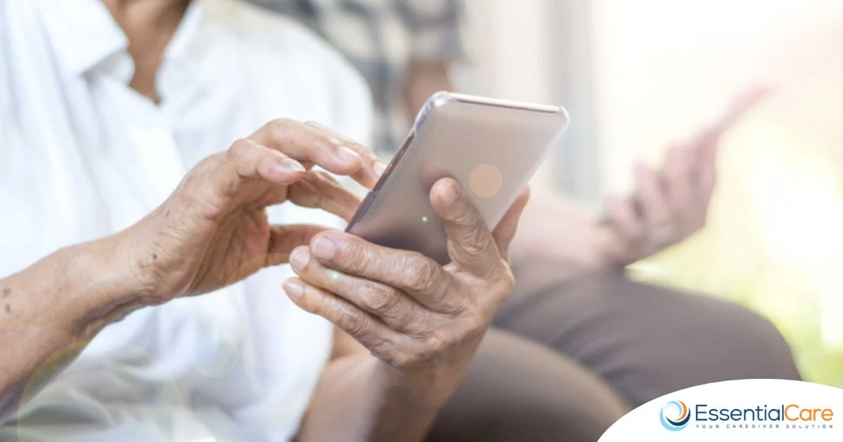 Senior using a smartphone with caregiver support, showcasing how home care technology helps seniors stay connected and independent